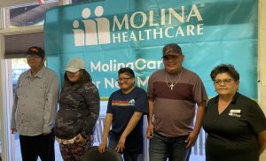 Five people standing in front of a Molina Healthcare banner.